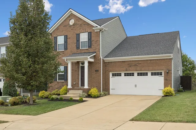 a front view of a house with a yard and garage