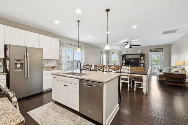 a kitchen with stainless steel appliances granite countertop a sink refrigerator and microwave