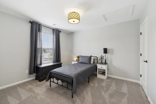 a bedroom with bed and a flat tv screen on dresser