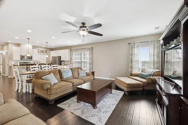 a kitchen with stainless steel appliances granite countertop a sink a stove a refrigerator a center island with wooden cabinets