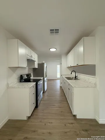 a large kitchen with stainless steel appliances kitchen island a large counter top and a stove top oven