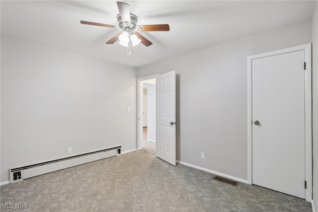 611 Wilson Street Struthers, OH 44471 - Photo 26 of 44 Unfurnished bedroom with a baseboard radiator, a ceiling fan, and light carpet