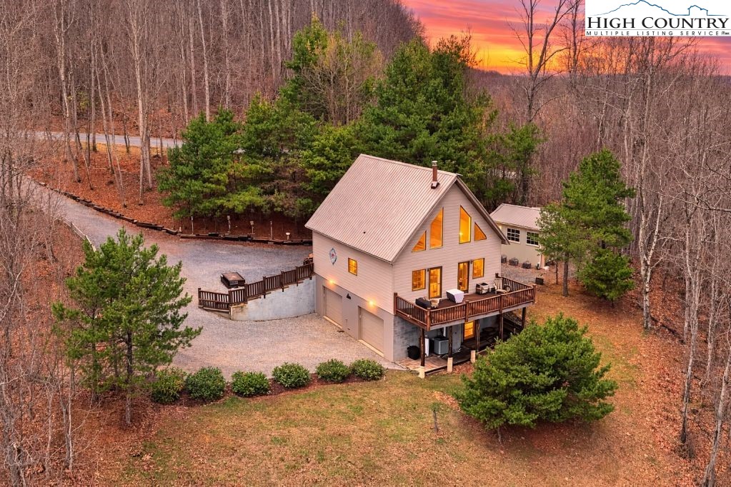 an aerial view of a house with a yard and a large tree