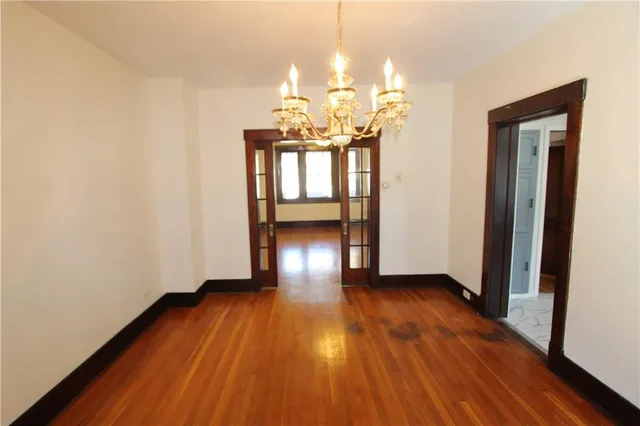 a view of a room with wooden floor and chandelier