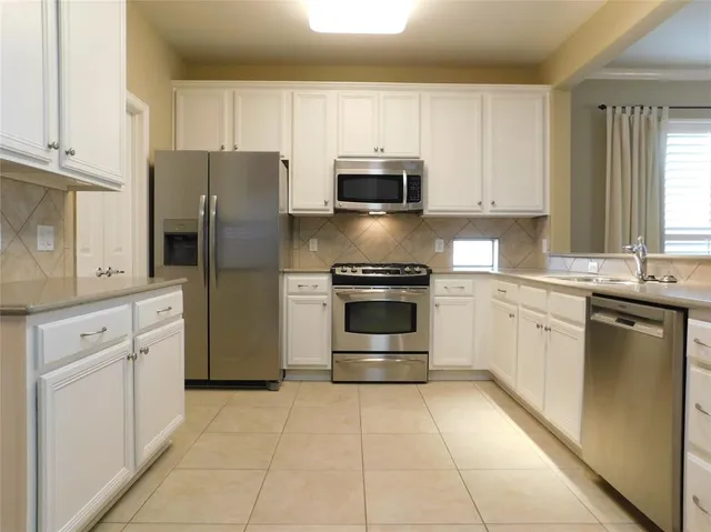 a kitchen with stainless steel appliances granite countertop a refrigerator and a stove top oven