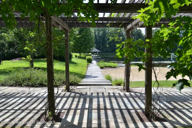 a view of a patio with table and chairs potted plants and large tree