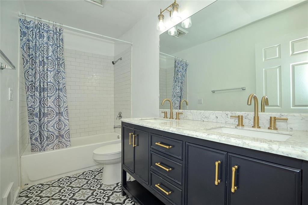 412 Colton Street Pittsburgh, PA 15209 - Photo 11 of 18 a bathroom with a granite countertop sink a toilet a mirror a bathtub and shower