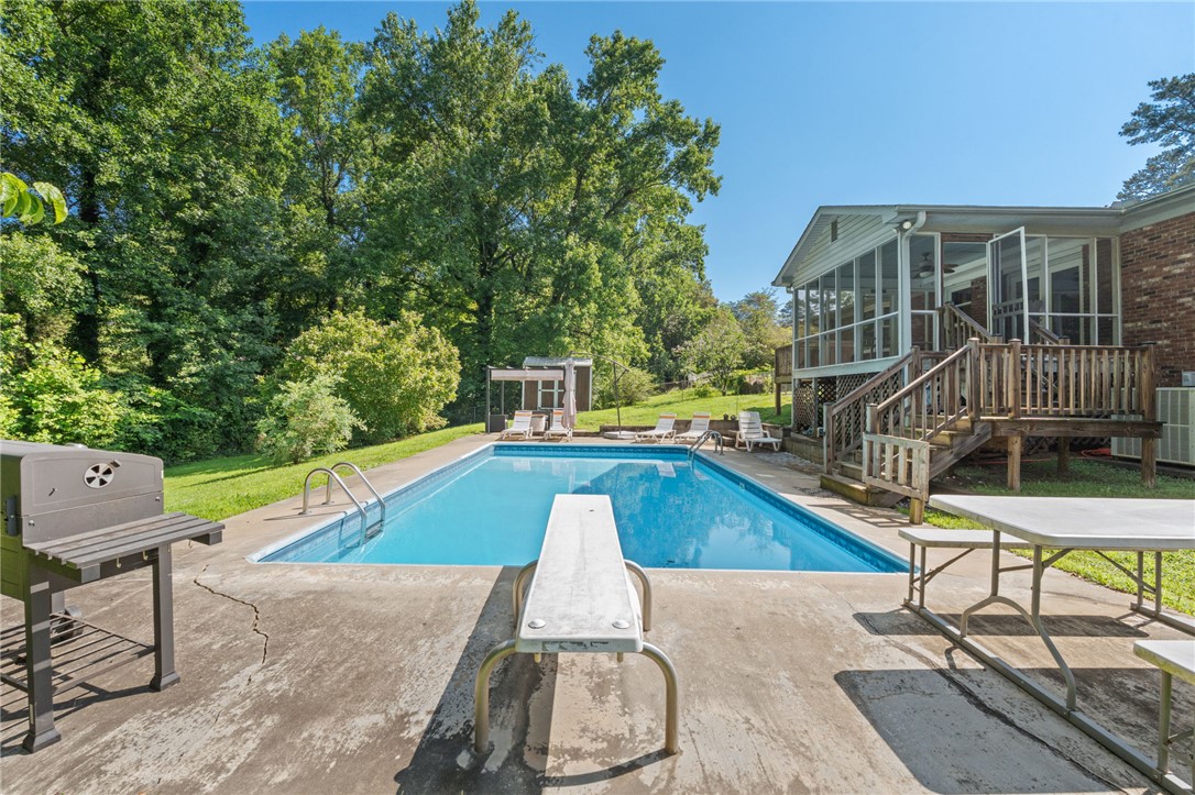 200 Echo Circle Easley, SC 29642 - Photo 26 of 35 An inviting backyard oasis offers a pristine swimming pool and a screened porch, perfect for enjoying sunny days.
