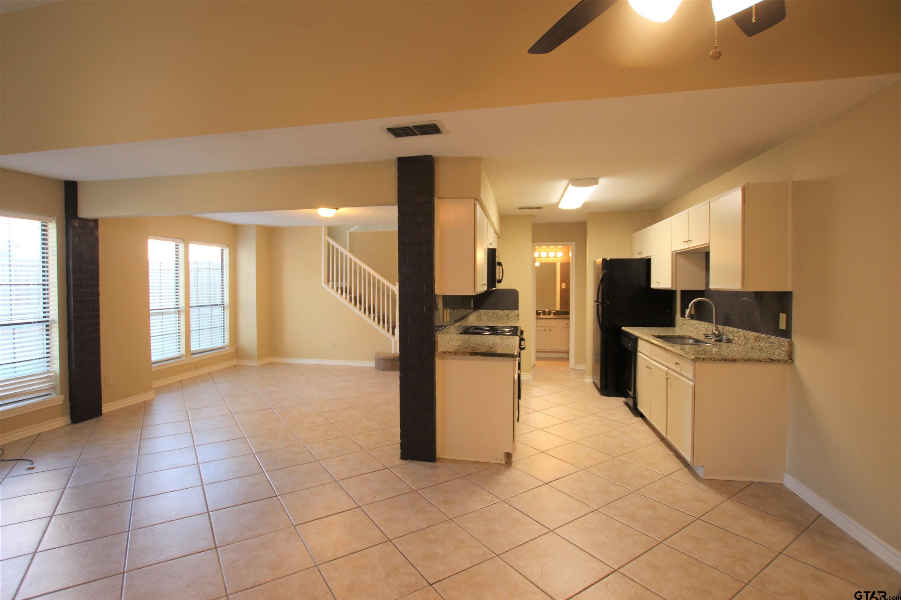 5875 Creekside Circle Tyler, TX 75703 - Photo 11 of 32 a large kitchen with cabinets and stainless steel appliances