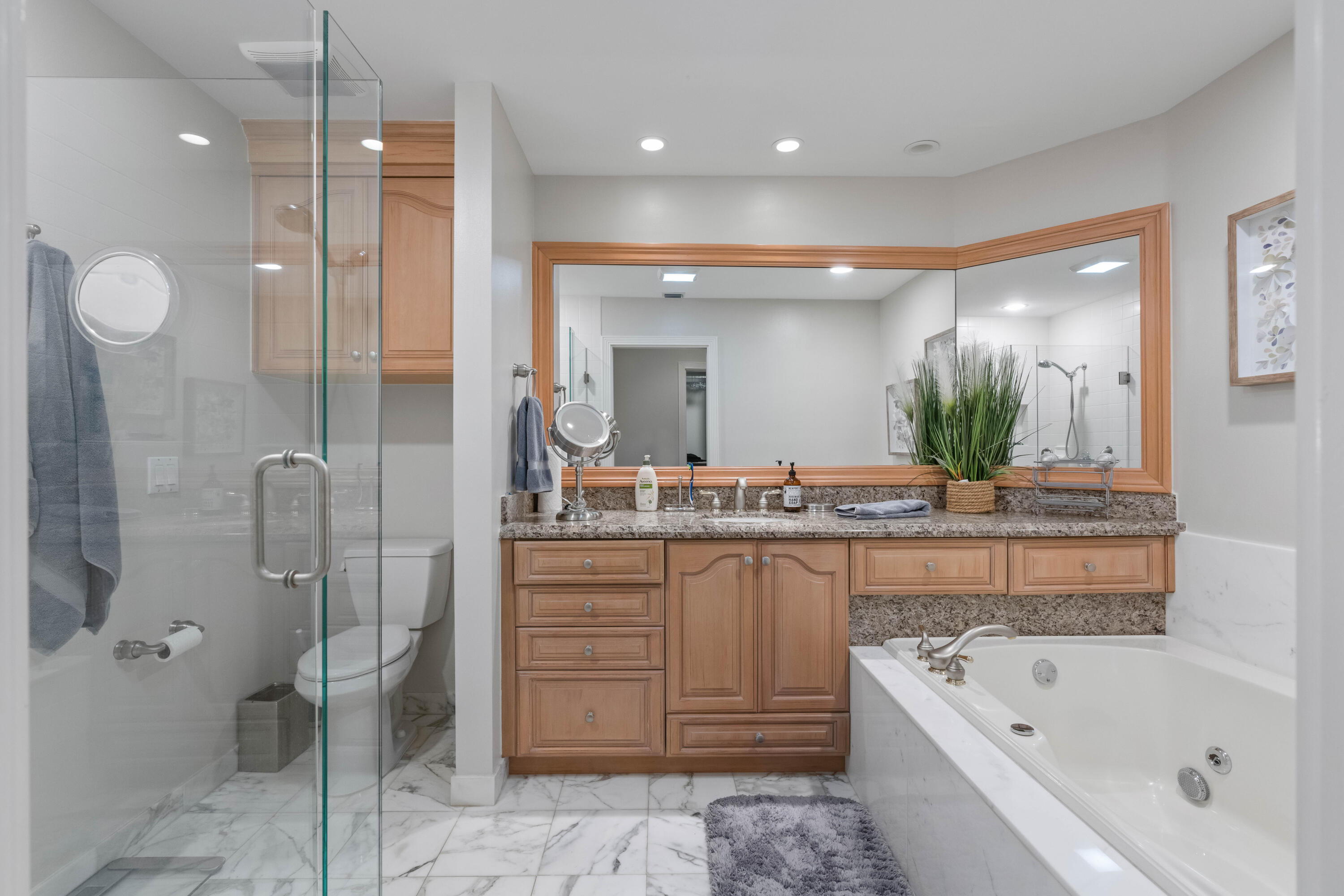 266 Eagle Drive Jupiter, FL 33477 - Photo 15 of 35 a bathroom with a granite countertop sink a toilet a mirror and bathtub