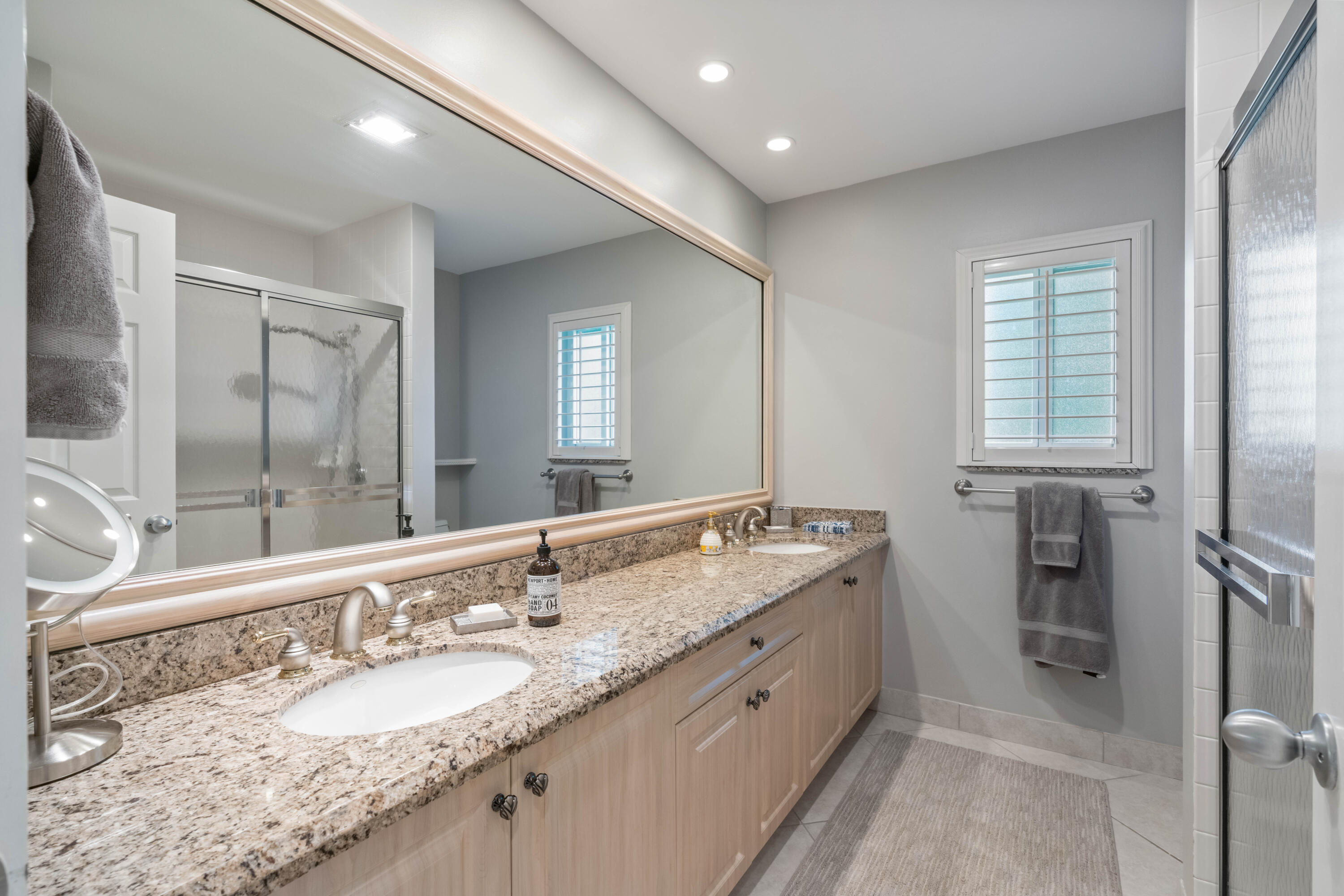 266 Eagle Drive Jupiter, FL 33477 - Photo 18 of 35 a bathroom with a granite countertop double vanity sink and a mirror