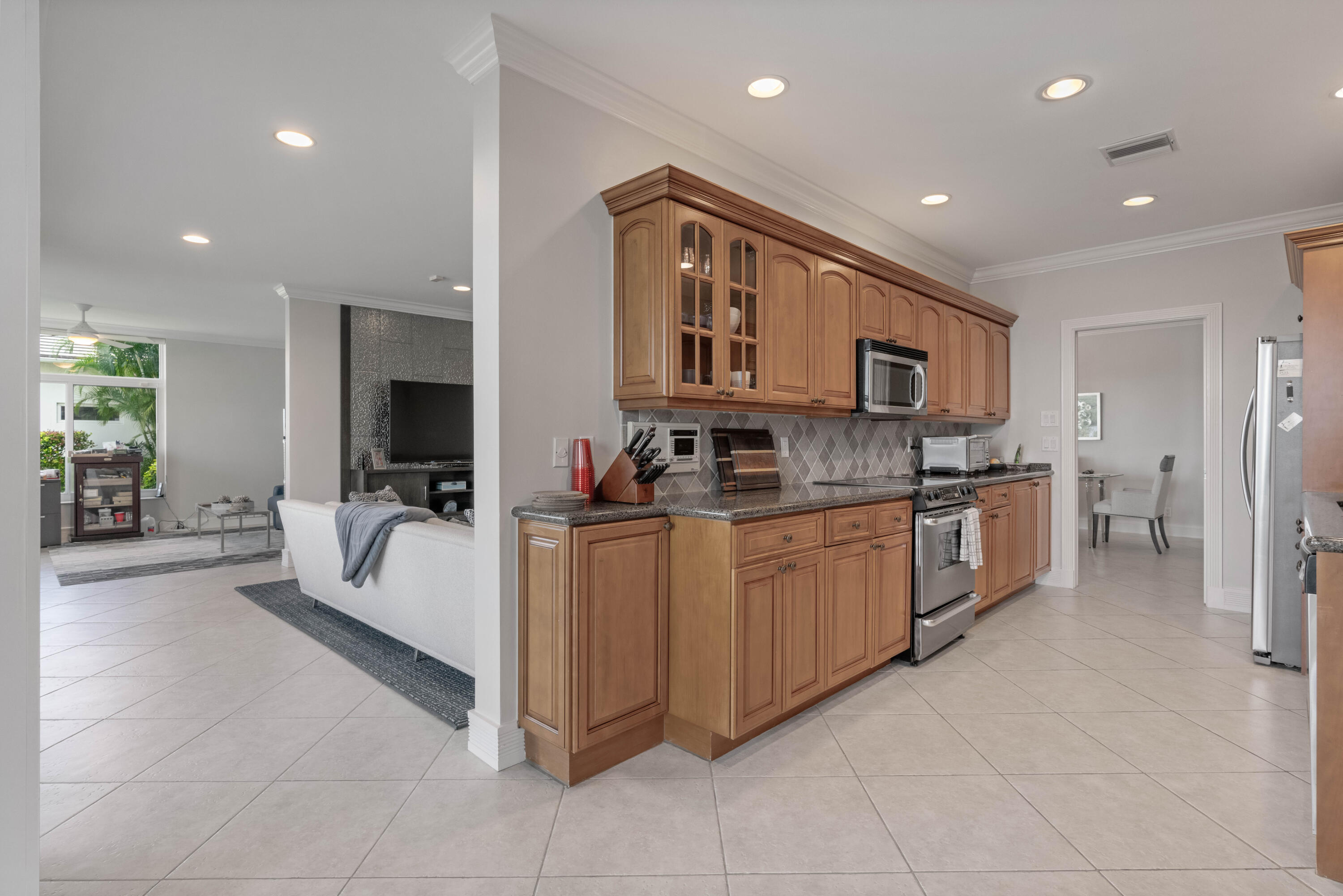 266 Eagle Drive Jupiter, FL 33477 - Photo 7 of 35 a large white kitchen with stainless steel appliances granite countertop lots of white cabinets a stove and a sink