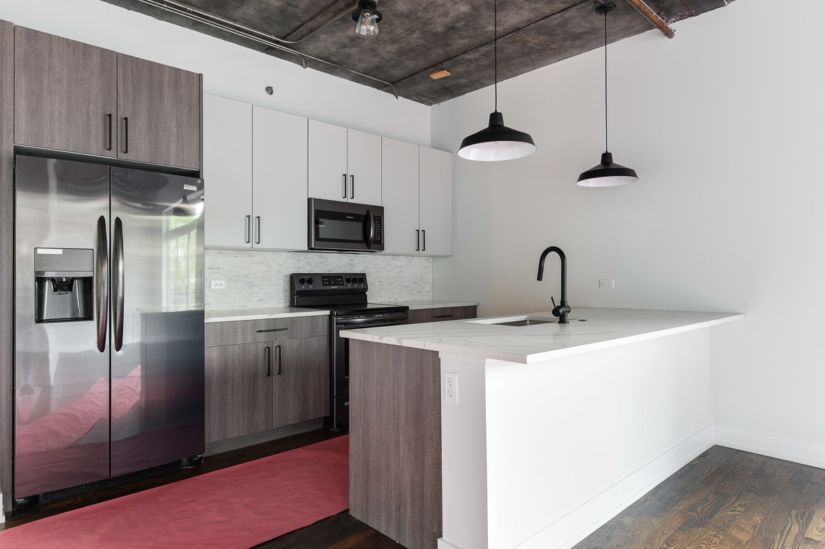 4720 North Sheridan Road, Unit 3D Chicago, IL 60640 - Photo 2 of 15 a kitchen with a sink stainless steel appliances and white cabinets