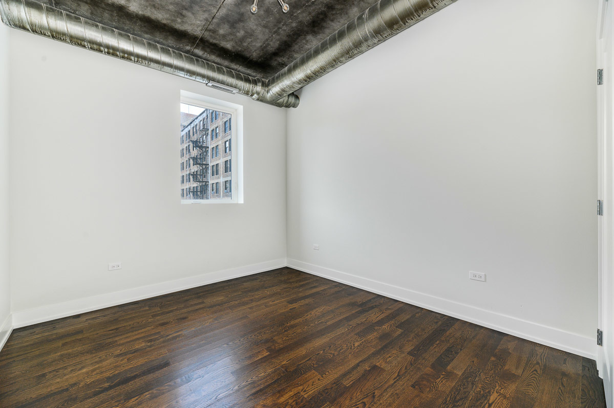 4720 North Sheridan Road, Unit 3D Chicago, IL 60640 - Photo 8 of 15 an empty room with wooden floor and windows