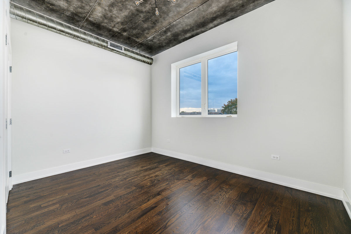 4720 North Sheridan Road, Unit 3D Chicago, IL 60640 - Photo 10 of 15 an empty room with wooden floor and windows