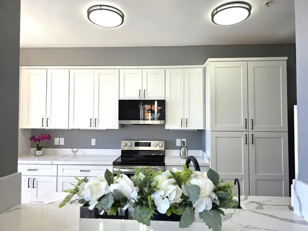 a kitchen with microwave a stove and cabinets