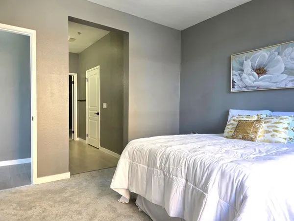 a bedroom with a bed and a painting on the wall