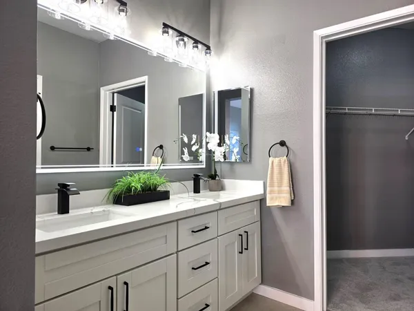 a bathroom with a double vanity sink and a mirror