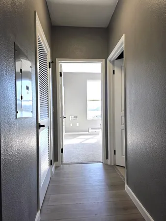 a view of a hallway with wooden floor