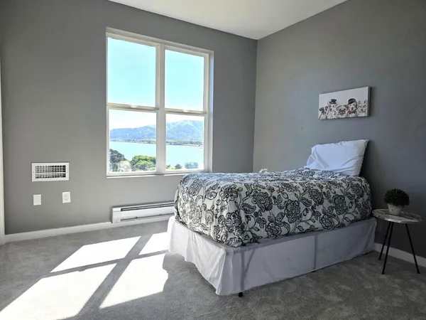 a bedroom with a bed and a large window