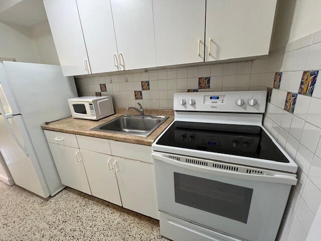 311 Inlet Way, Unit 10 Palm Beach Shores, FL 33404 - Photo 10 of 18 a kitchen with a stove and white cabinets