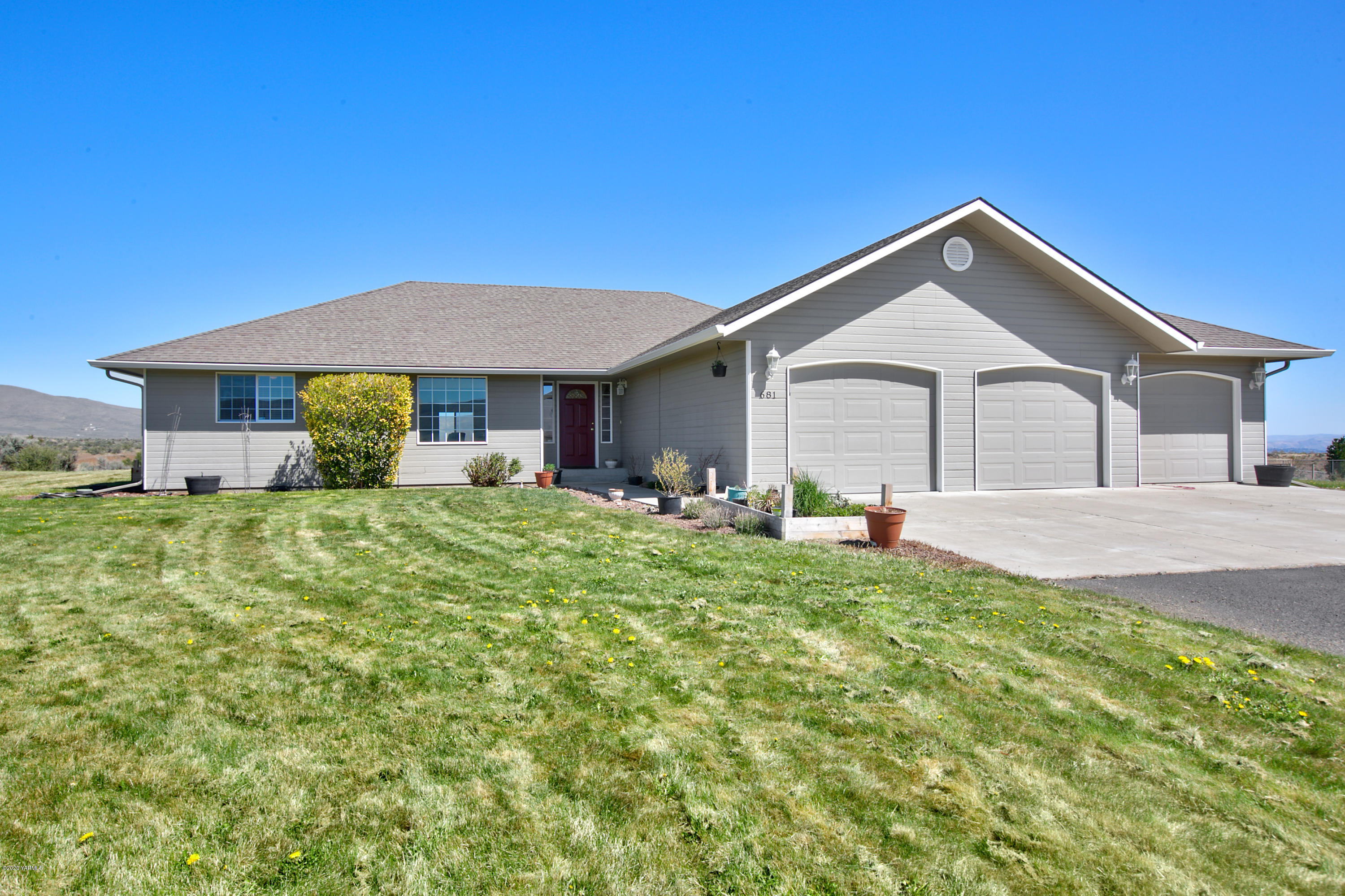 681 Red Tail Road Yakima, WA 98908 - Photo 1 of 21 a front view of a house with a yard and garage