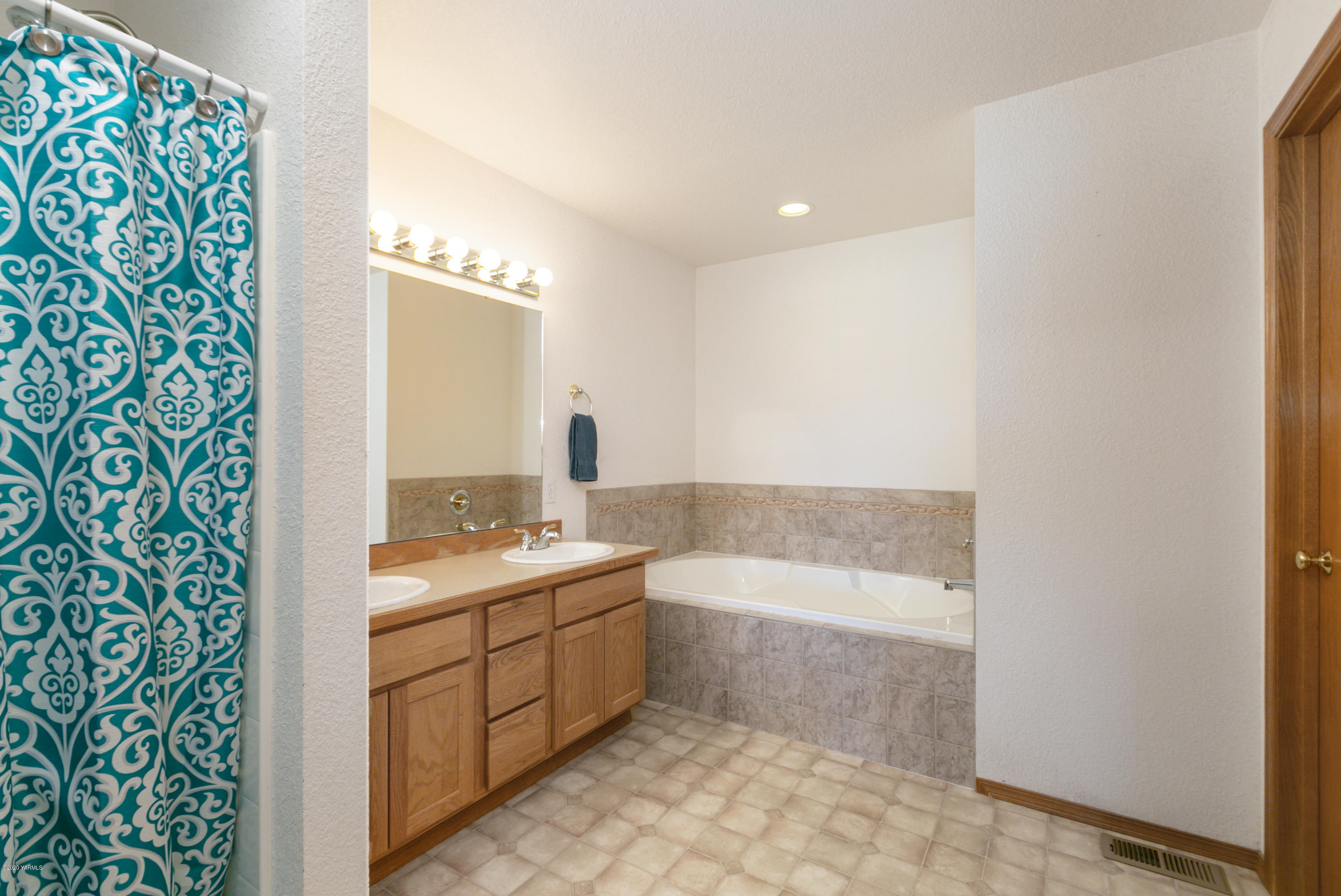 681 Red Tail Road Yakima, WA 98908 - Photo 17 of 21 a bathroom with a bathtub sink and mirror