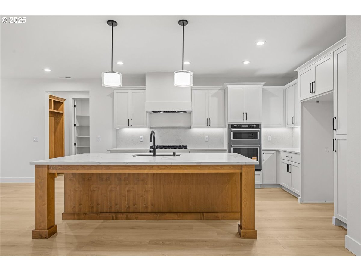 3518 North 11th Circle Ridgefield, WA 98642 - Photo 11 of 44 a kitchen with kitchen island white cabinets and stainless steel appliances