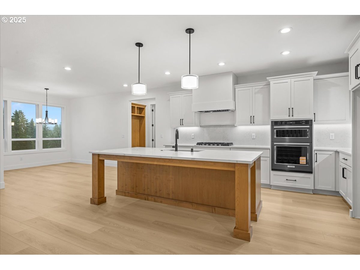 3518 North 11th Circle Ridgefield, WA 98642 - Photo 12 of 44 a living room with stainless steel appliances granite countertop a kitchen island a stove a sink a refrigerator and a wooden floors