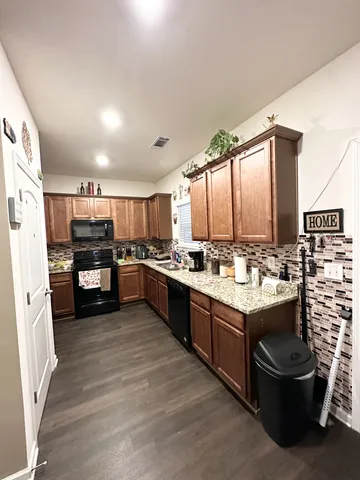a large kitchen with a large counter top stainless steel appliances and cabinets