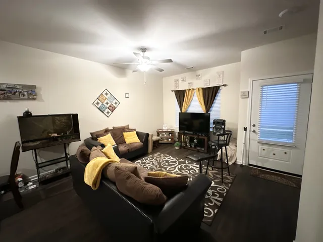 a living room with furniture and a wooden floor