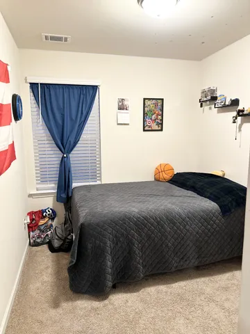 a bedroom with a bed and a large mirror