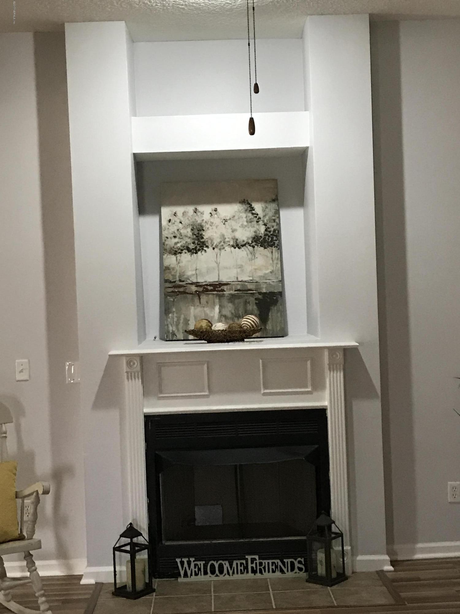 13290 Pacemaker Drive Jacksonville, FL 32225 - Photo 19 of 40 a fireplace with a clock on top of it