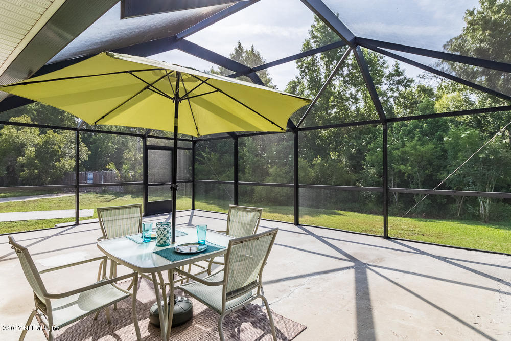 13290 Pacemaker Drive Jacksonville, FL 32225 - Photo 2 of 40 a view of a swimming pool with a table and chairs under an umbrella