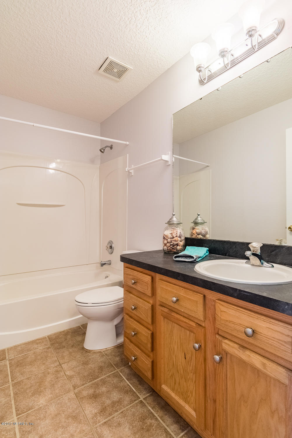 13290 Pacemaker Drive Jacksonville, FL 32225 - Photo 22 of 40 a bathroom with a granite countertop sink a toilet and bathtub