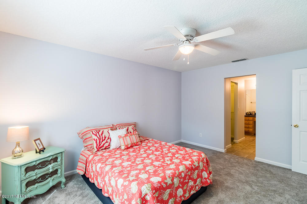 13290 Pacemaker Drive Jacksonville, FL 32225 - Photo 10 of 40 a bedroom with a bed and a chandelier