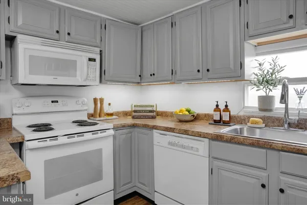 a kitchen with granite countertop white cabinets and white appliances