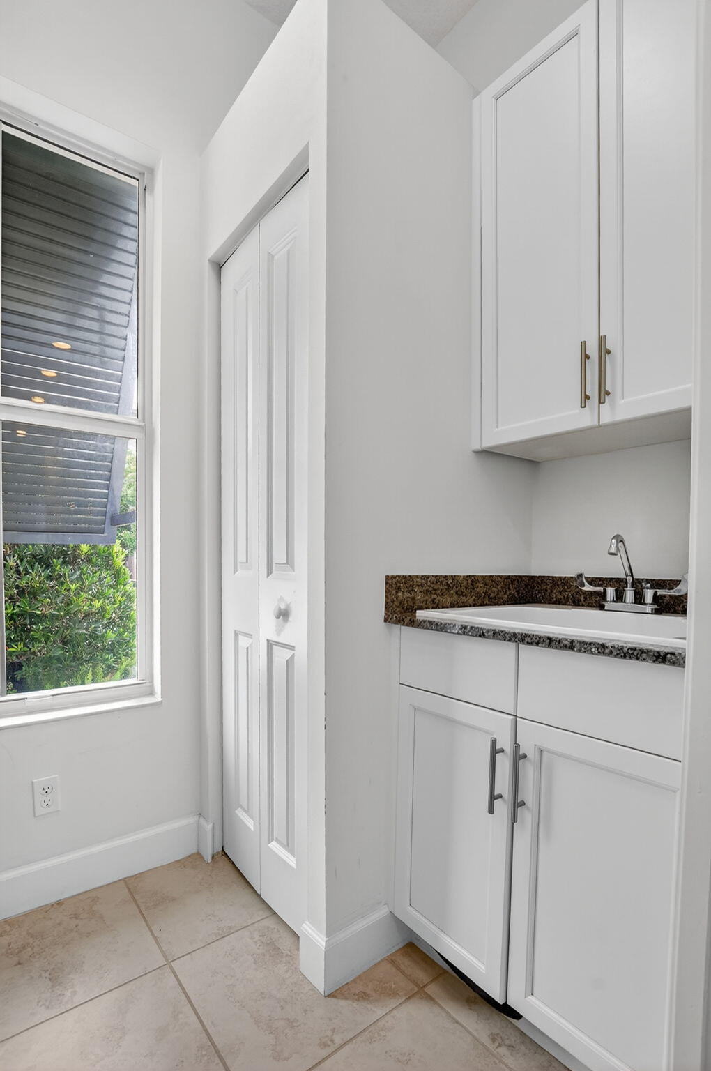 6675 Quiet Wave Trail Boca Raton, FL 33433 - Photo 20 of 65 a kitchen with white cabinets and a window