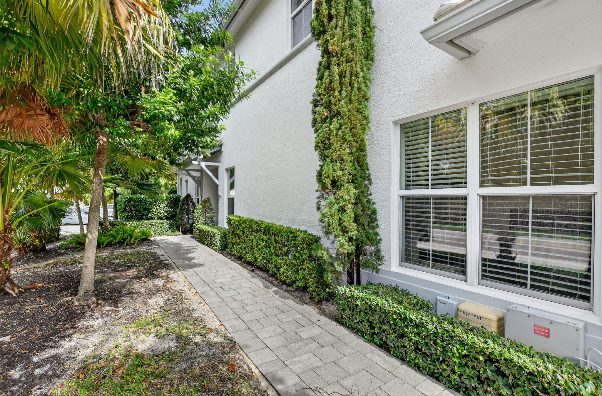 6675 Quiet Wave Trail Boca Raton, FL 33433 - Photo 3 of 65 a view of a pathway that has potted plants and a large tree