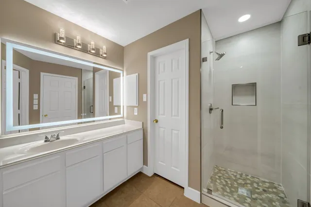 a bathroom with a shower sink and mirror