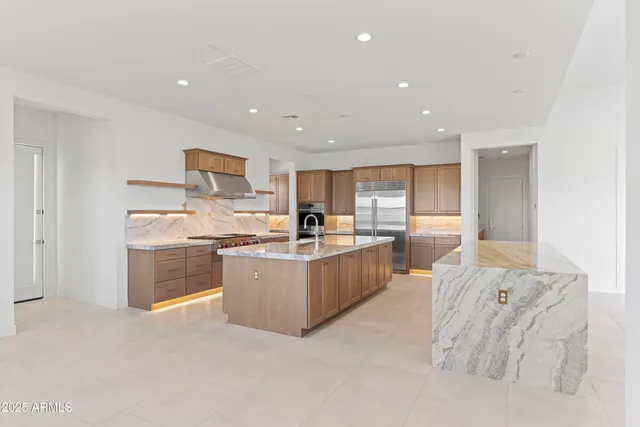 a kitchen with stainless steel appliances granite countertop a refrigerator and a sink