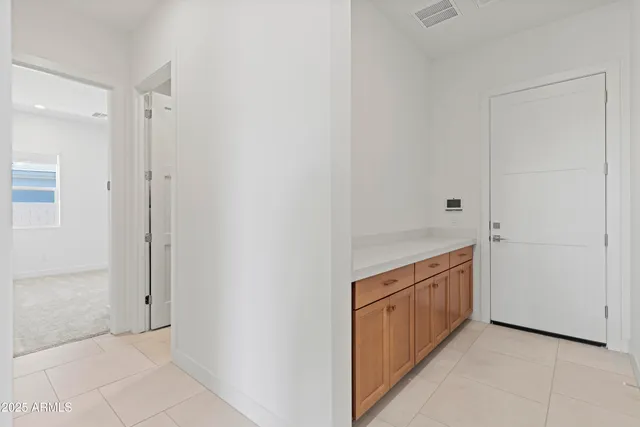 a view of an empty room with closet and a bathroom