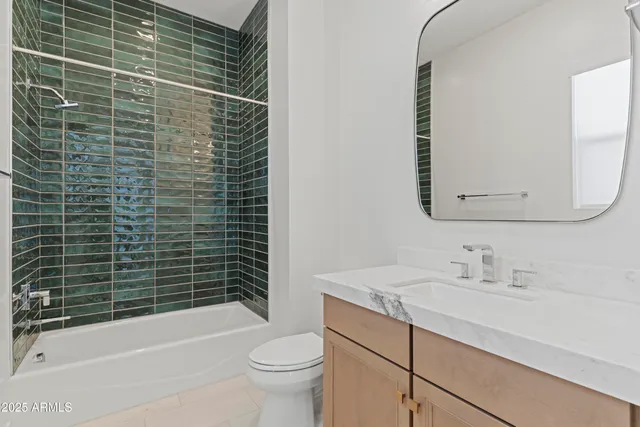 a view of a white house with a yard plants and large tree