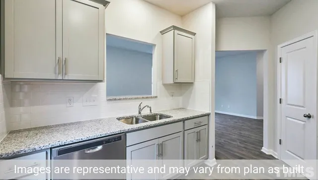 a kitchen with stainless steel appliances granite countertop a sink and a white cabinets