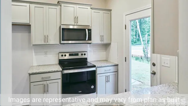 a kitchen with stainless steel appliances white cabinets and a stove top oven