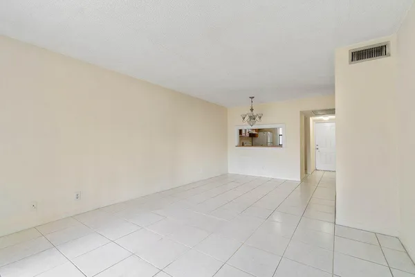 an empty room with cabinet and windows