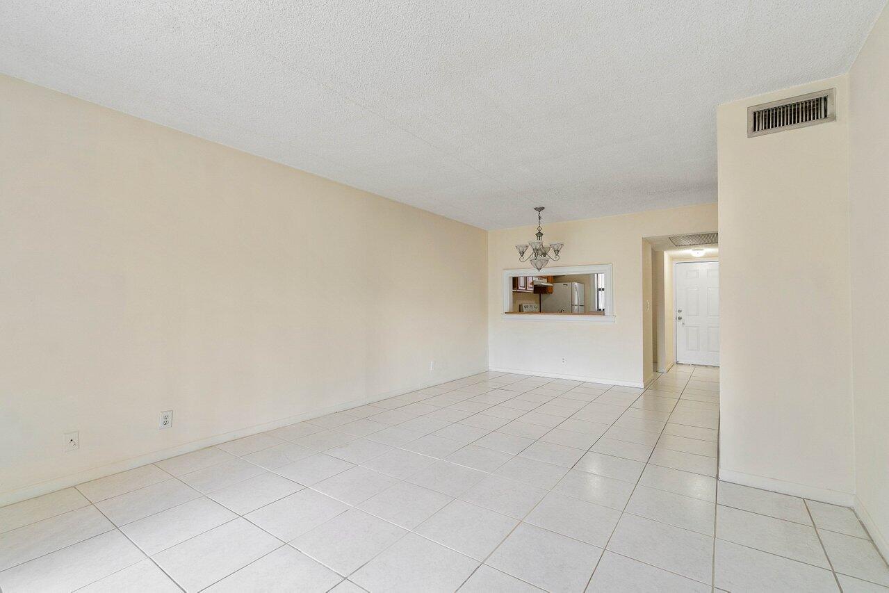 6736 Palmetto Circle South, Unit 105 Boca Raton, FL 33433 - Photo 11 of 28 an empty room with cabinet and windows