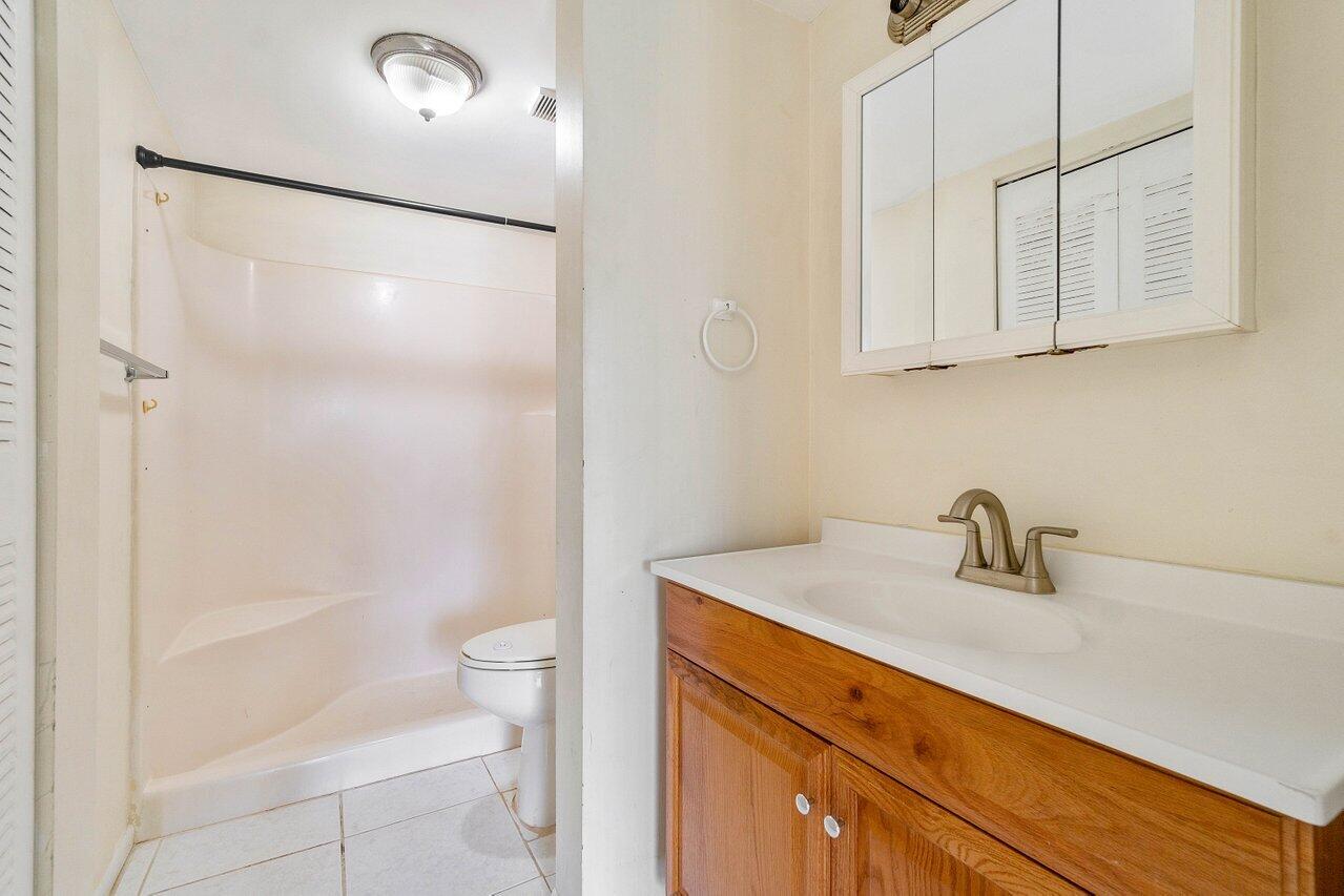 6736 Palmetto Circle South, Unit 105 Boca Raton, FL 33433 - Photo 18 of 28 a bathroom with a sink a toilet and shower