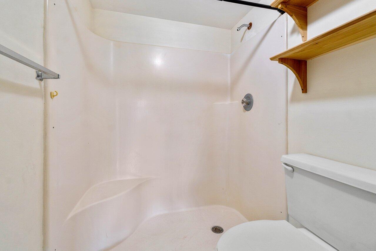 6736 Palmetto Circle South, Unit 105 Boca Raton, FL 33433 - Photo 19 of 28 a bathroom with a shower and a toilet