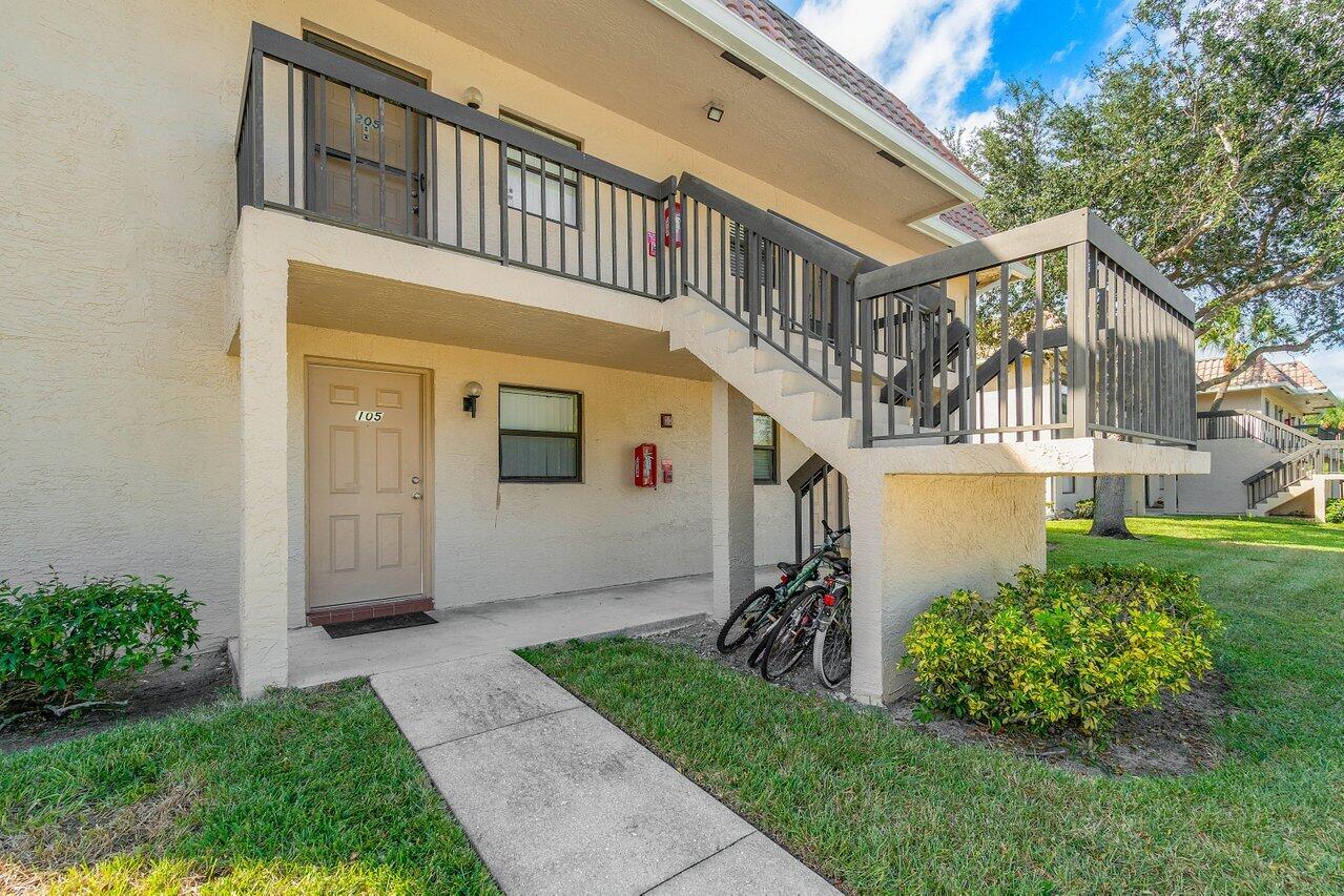 6736 Palmetto Circle South, Unit 105 Boca Raton, FL 33433 - Photo 2 of 28 a front view of a house with garden